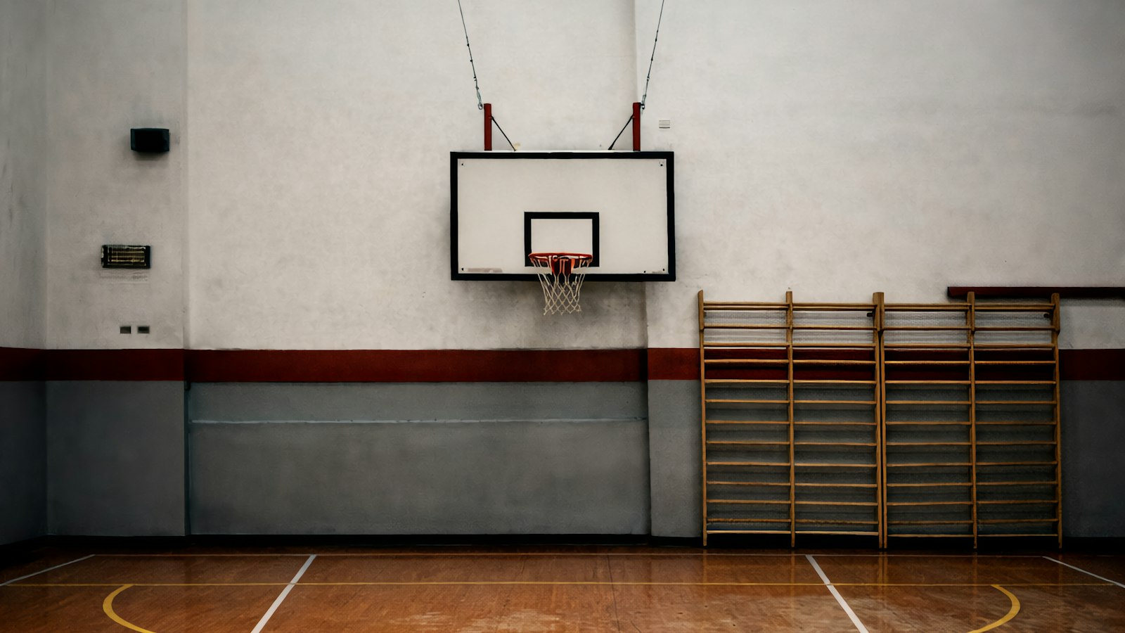 Empty indoor basketball court with polished wooden floor