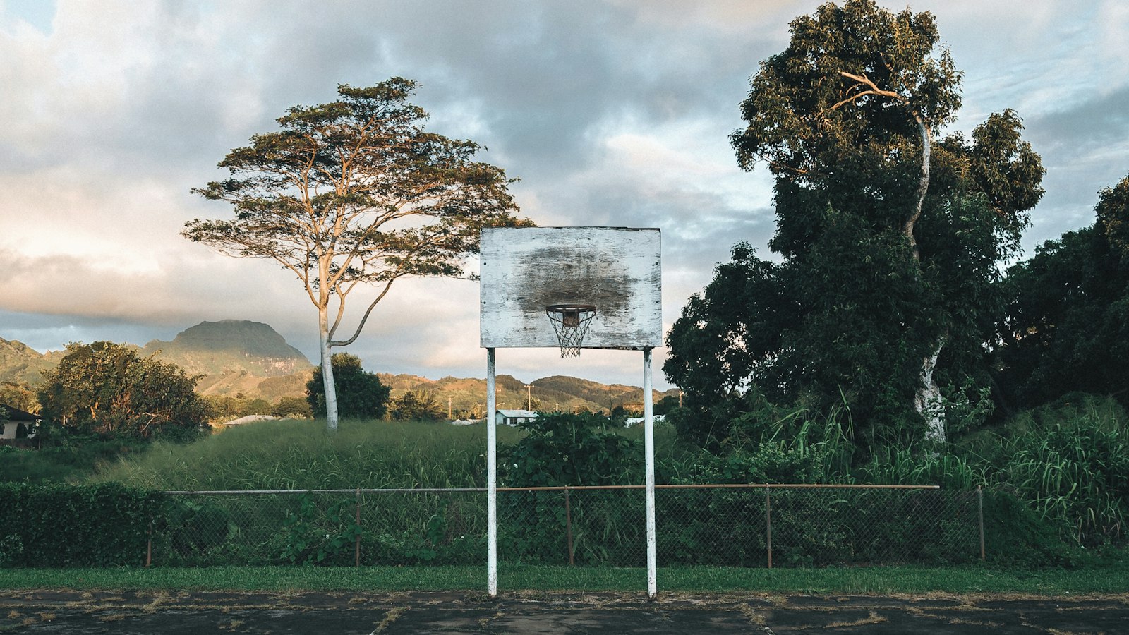 Old outdoor basketball hoop in warm evening light
